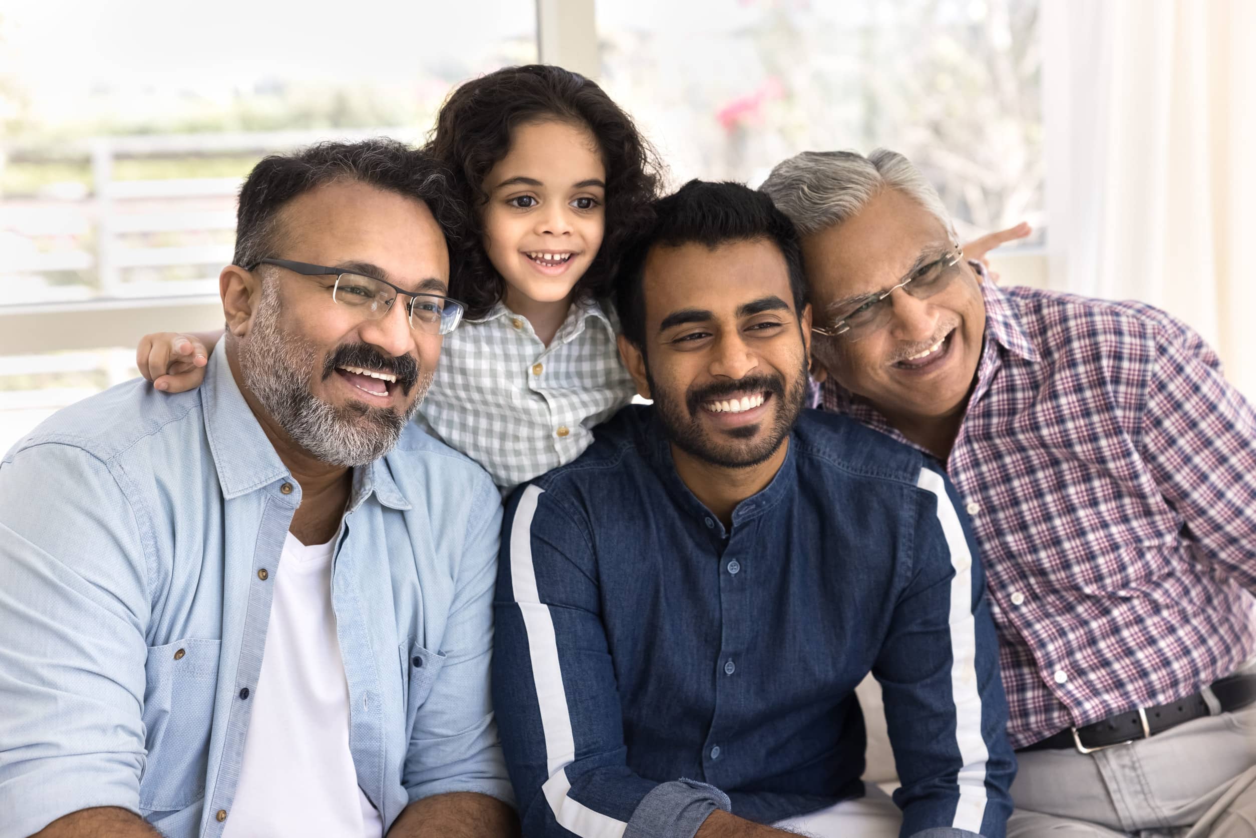 Four generations of one family together at home, from a young girl to her great-grandfather, illustrating relocation trends by generation
